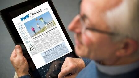 Foto: Mann liest VdK-Zeitung über ein Tablet