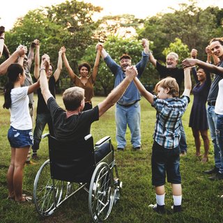 Gruppe von Menschen im Park, die sich an den Händen hält