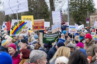 Man sieht Demonstrierende auf einer Demo in Erding gegen Rechtsextremismus. Einige halten Schilder hoch. 