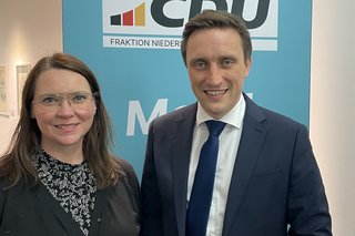 Andrea Nacke und Sebastian Lechner lächelnd vor einem CDU-Logo