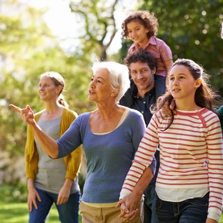 Frauen und Männer unterschiedlichen Alters und zwei Kinder als Gruppe im Park