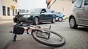 Das Bild zeigt ein Fahrrad das nach einem Unfall auf dem Boden liegt