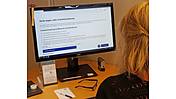 Foto einer Frau am PC bei der Recherche zur Erwerbsminderungsrente
