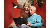 Foto eines älteren Paares, das auf einem Tablet liest