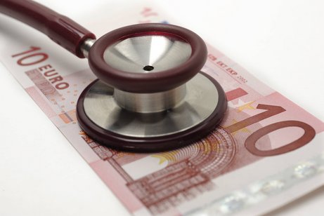 Steigende Kosten bei den Krankenkassenbeiträgen Ein Zehn-Euro-Schein, auf dem ein Stethoskop liegt
