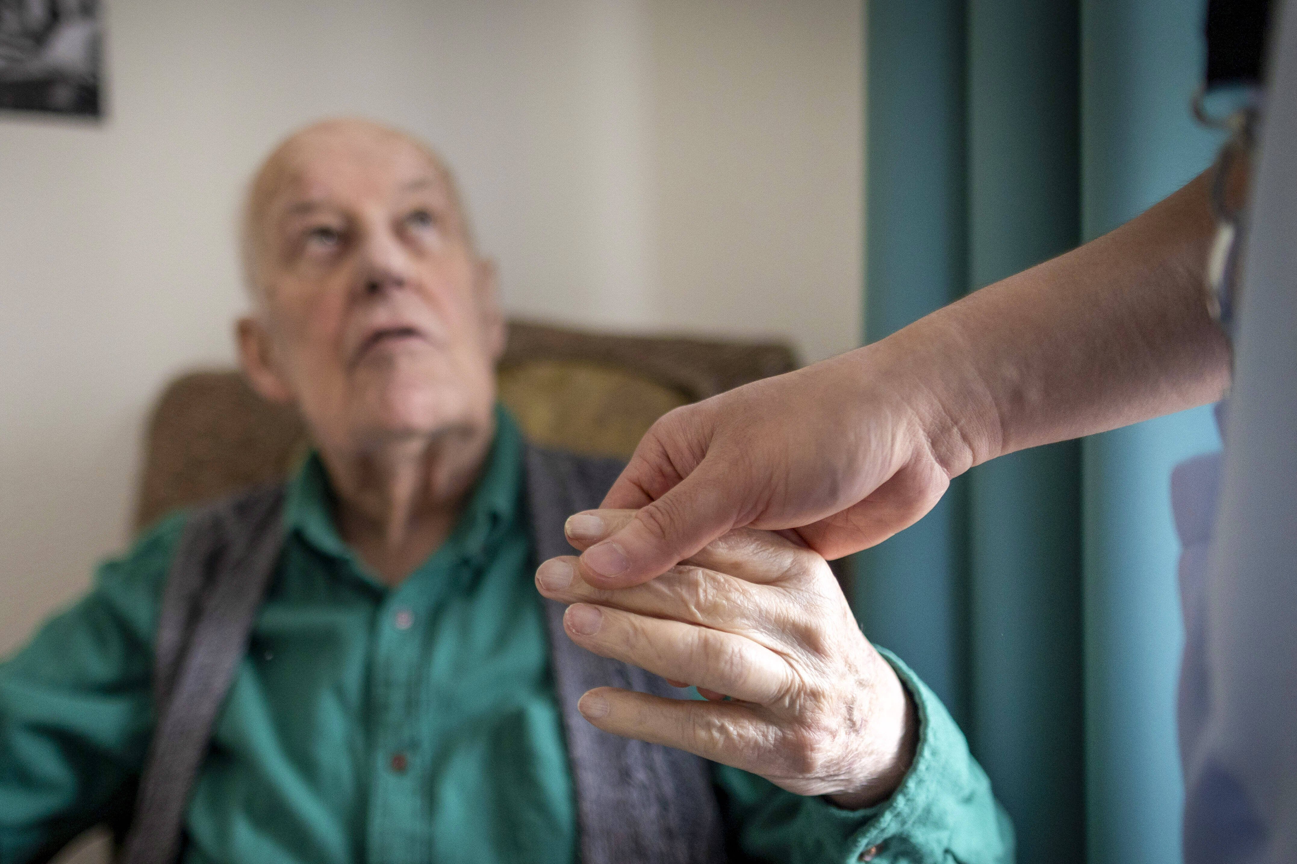 Hand hält die Hand eines älteren Mannes