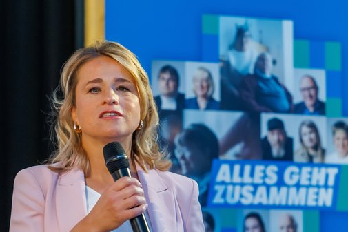 VdK-Präsidentin Verena Bentele bei ihrer Rede, im Hintergrund ein Roll-up der Aktion Alles geht zusammen.