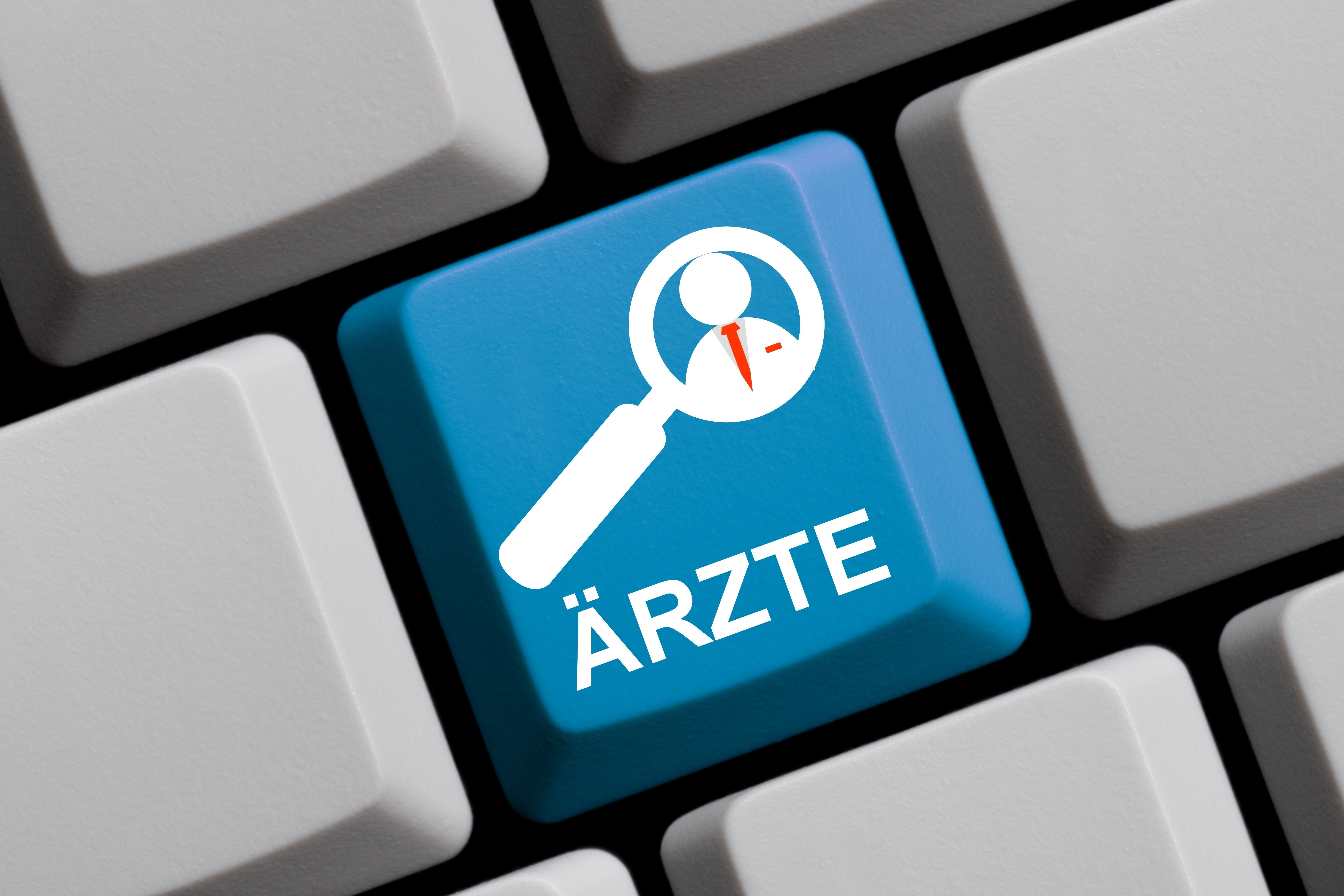 Ärzte-Suche online Tastatur in Nahaufnahme. Eine Taste ist blau, darauf sieht man eine Lupe und das Wort "Ärzte"
