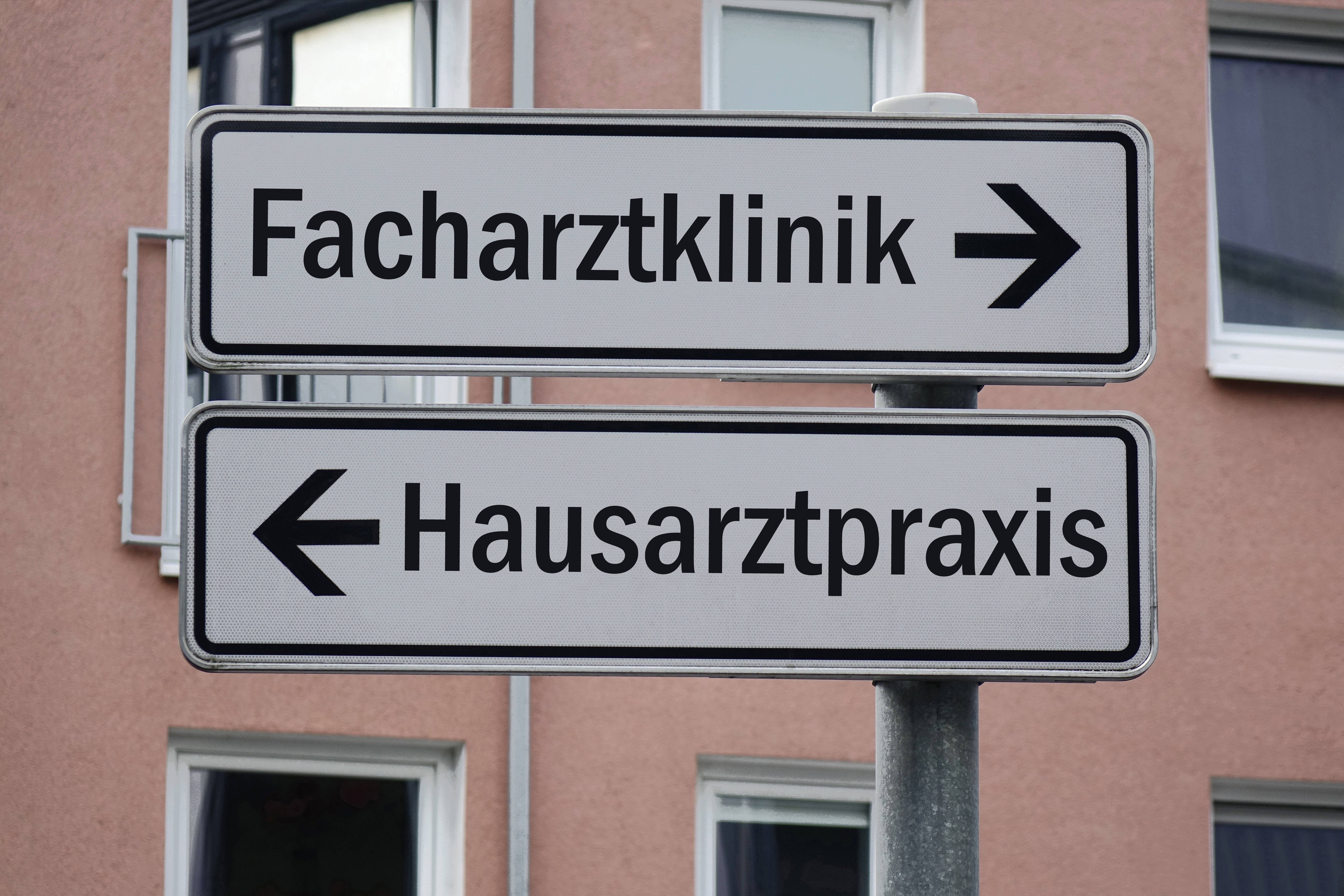 Ein Wegweiser mit zwei Schildern. Der eine zeigt nach rechts mit der Aufschrift "Facharztklinik", der andere nach links mit der Aufschrift "Hausarztpraxis"