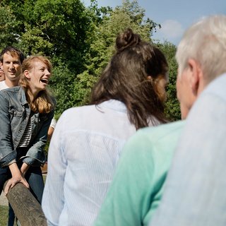 Gruppe von Männern und Frauen unterschiedlichen Alters gemeinsam auf einer Wippe.