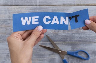 "We can't" anstelle von "We can" Hände halten einen Papierstreifen mit der Aufschrift “We can't” (Englisch für “Wir können nicht”)