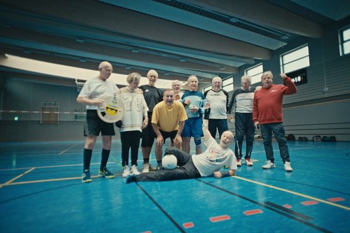 Alles geht zusammen - Gemeinschaft beim Sport Gruppenfoto einer Volleyballmannschaft, die aus älteren Sportlern besteht, in einer Turnhalle.