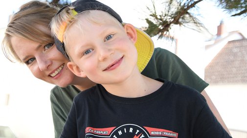Anton und seine Mutter Der sechsjährige Anton und seine Mutter schauen gemeinsam in die Kamera, beide lächeln.