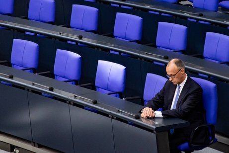 Friedrich Merz im Bundestag Bundeskanzler Friedrich Merz am Tag seiner Vereidigung im Bundestag, er sitzt allein im Plenum, schaut auf seine Hände.