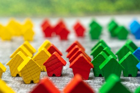 Wohngeld nicht kürzen Bunte kleine Holzhäuser als Symbol für Wohnen und Wohnungsmarkt