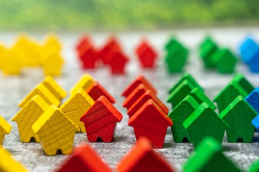 Wohngeld nicht kürzen Bunte kleine Holzhäuser als Symbol für Wohnen und Wohnungsmarkt