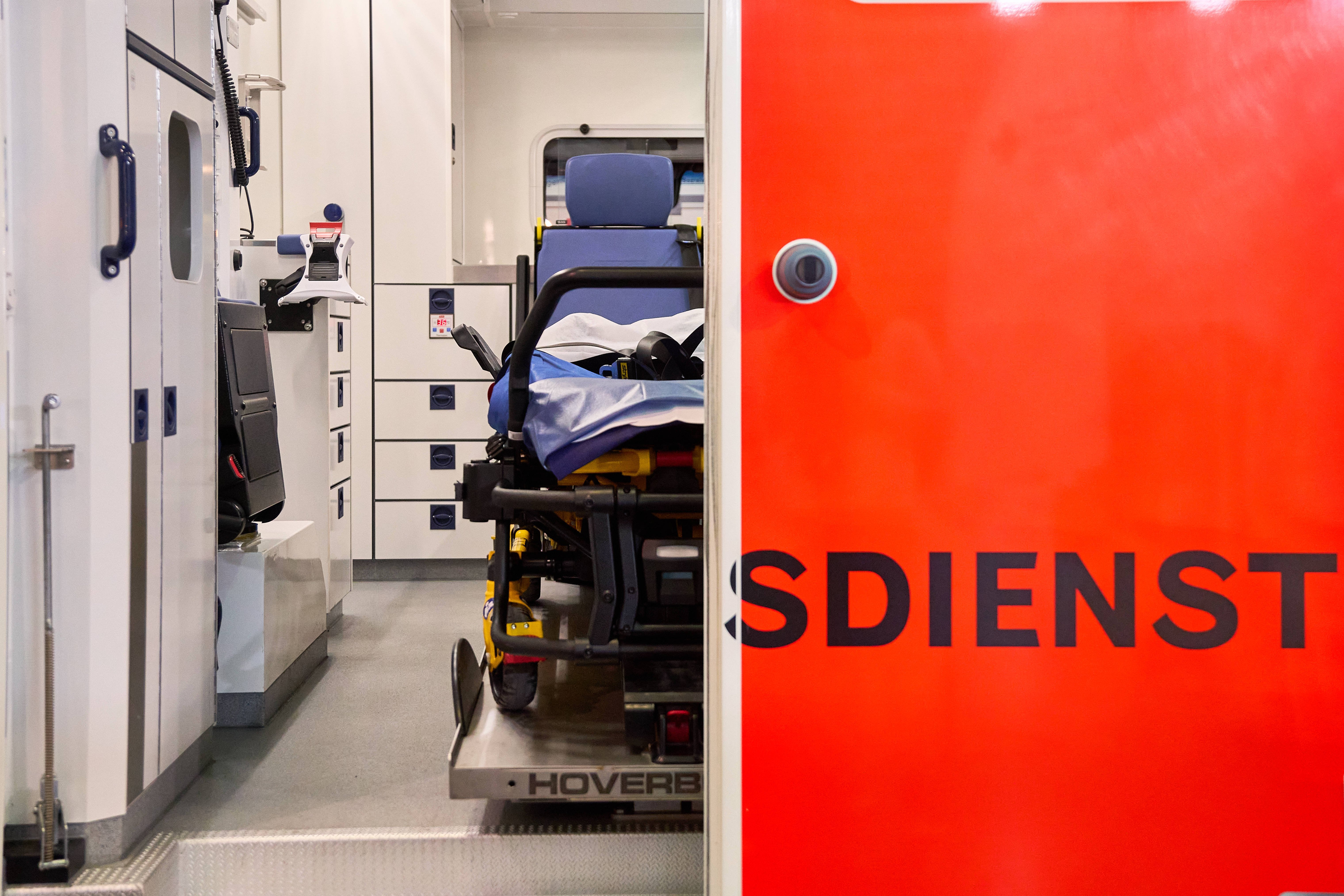 Rettungsdienst Blick in einen Rettungswagen, die linke Tür ist geöffnet und gewährt den Blick ins Innere, die rechte Tür ist geschlossen, so dass nur die Buchstaben "sdienst" des Wortes Rettungsdienst zu lesen sind.
