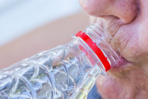 Eine &auml;ltere Frau trinkt Wasser aus einer Plastikflasche