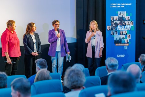 Auf der Bühne vor der Kinoleinwand stehen Katharina Schurk, Katarin Peranic, Claudia Kepp und Verena Bentele nebeneinander.