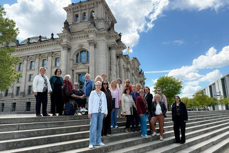 Gruppenfoto: Die VdK-Bundesfrauenkommission steht auf den Stufen vor dem Bundestag in Berlin.