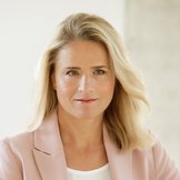 Das Foto zeigt Verena Bentele, sie sitzt in einem grauen Sessel und hat einen Arm auf der Lehne abgelegt