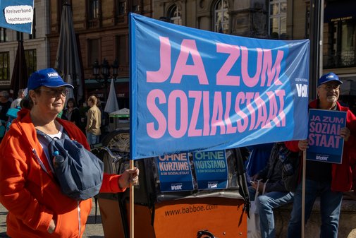 Demo-Teilnehmer tragen ein VdK-Banner mit "Ja zum Sozialstaat"