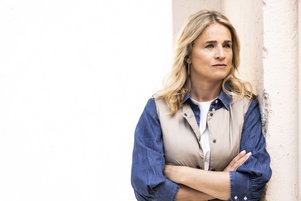 Verena Bentele Verena Bentele steht mit vor der Brust verschränkten Armen an eine Wand gelehnt, blickt ernst zur Seite.