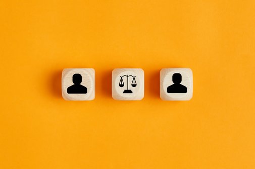 Gerichtsverfahren Drei Würfel mit Symbolen vor gelbem Hintergrund. Auf dem mittleren Würfel ist ein Waagen-Symbol, auf den beiden anderen der Umriss einer Person.