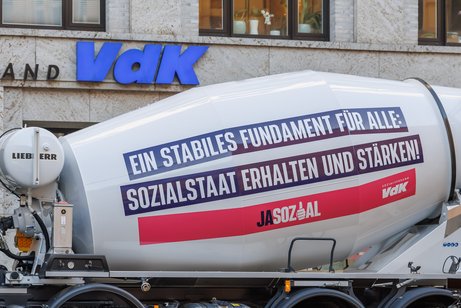 Ein Betonmischer steht vor der Bundesgeschäftsstelle des VdK in Berlin-Mitte. Auf dem Fahrzeug steht "Ein stabiles Fundament für alle: Sozialstaat erhalten und stärken. Jasozial".