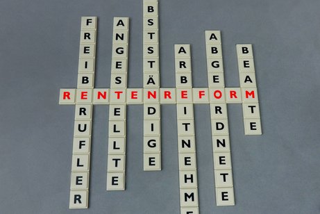 Quer liegende Scrabble-Buchstaben bilden das Wort Rentenreform, längst liegen mehrere andere Wörter wie Freiberufler, Beamte, Selbstständige, Angestellte, Arbeitnehmer