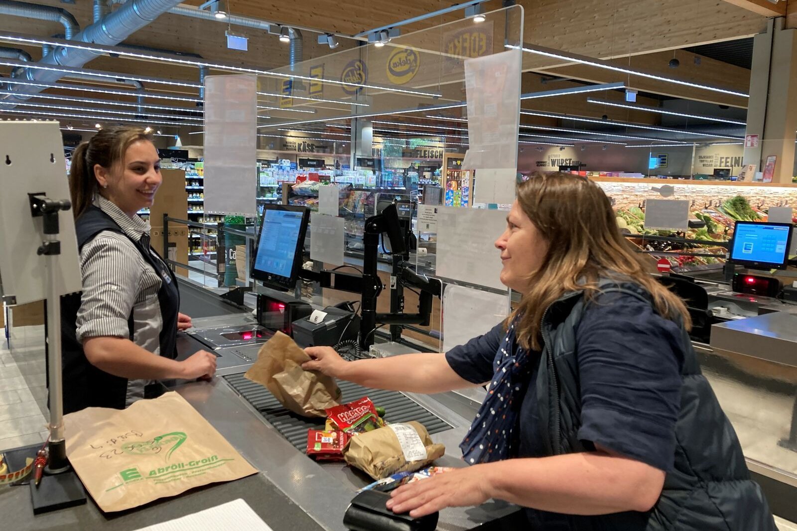Ratschkasse VdK Bayern Kassiererin Elli Nosha und eine Kundin an der "Ratschkasse" im bayerischen Edeka-Supermarkt.