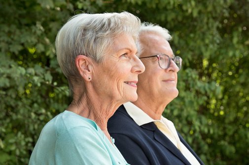 Seniorenpaar Eine ältere Frau und ein älterer Mann nebeneinander, sie blicken ernst in die Ferne.