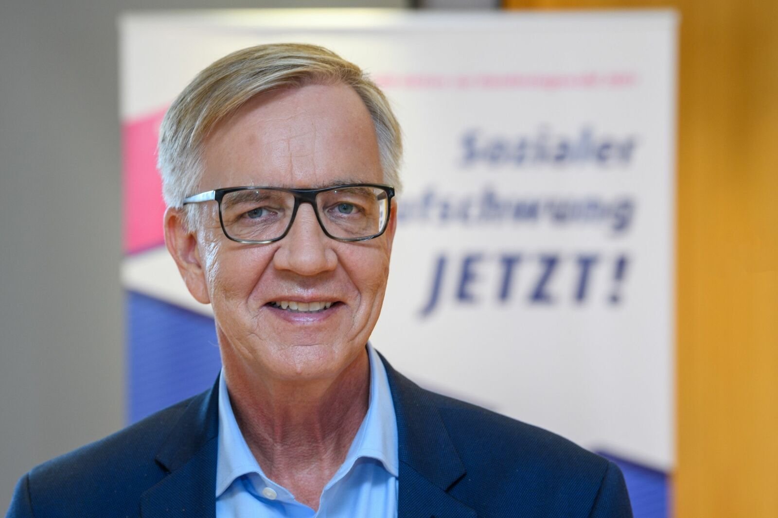 Das Portraitfoto zeigt Dietmar Bartsch vor dem Hintergrund der VdK-Kampagne "Sozialer Aufschwung jetzt!"