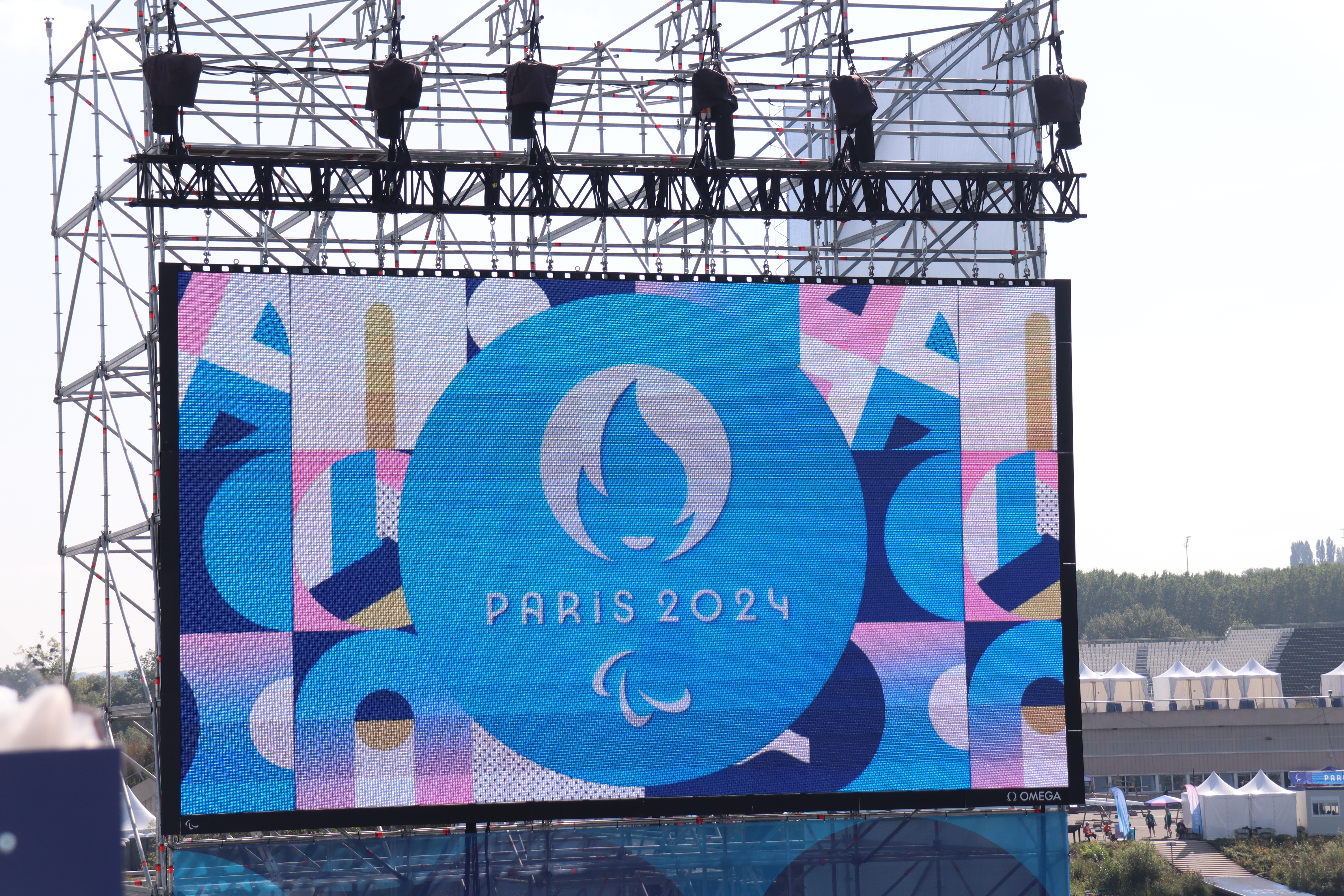 Ein bunt leuchtendes gro&szlig;es Display mit der Aufschrift "Paris 2024"