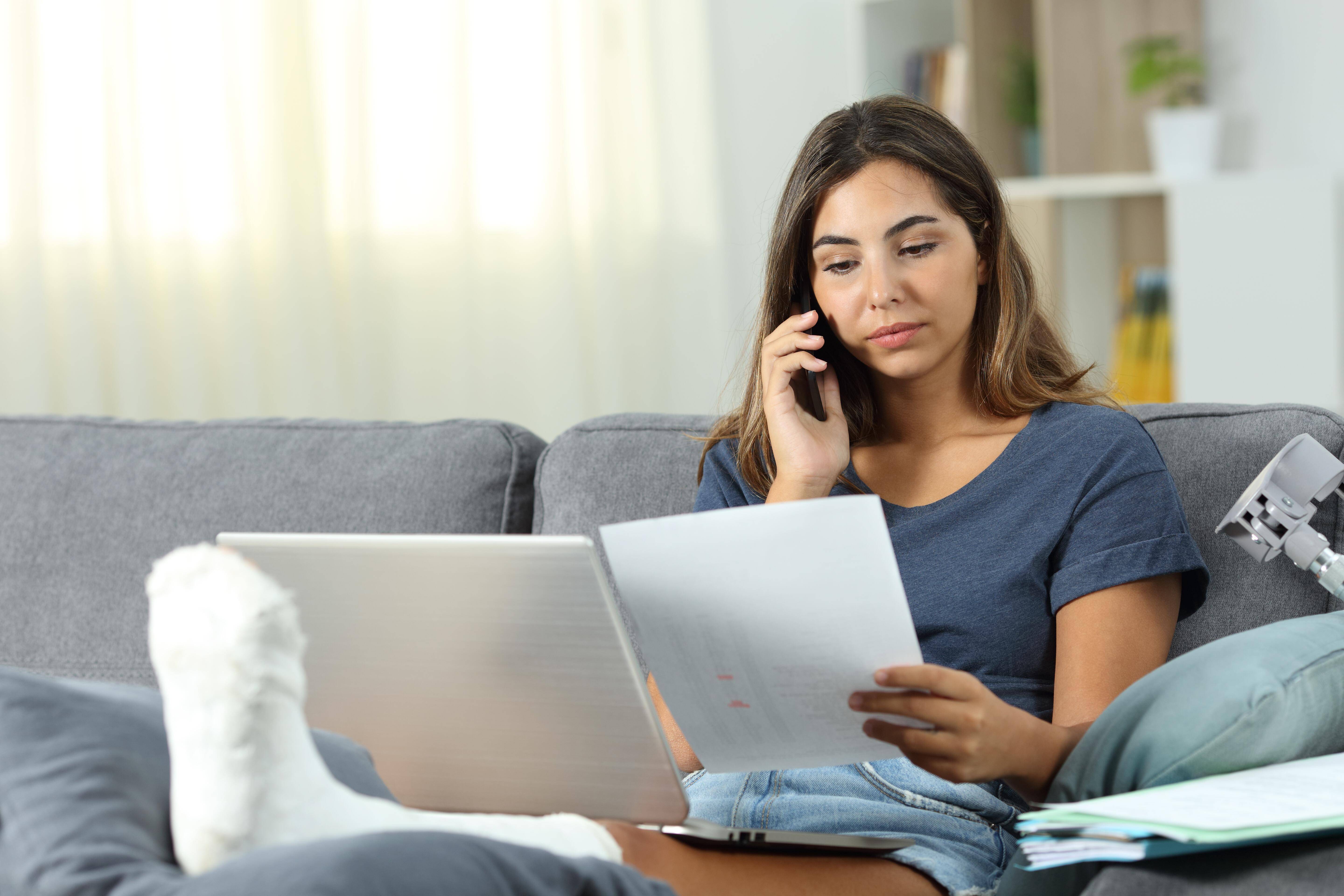 Info-Telefon für Patientinnen und Patienten Eine junge Frau mit einem Gipsbein sitzt auf einem Sofa und telefoniert, in der Hand hält sie ein Schreiben