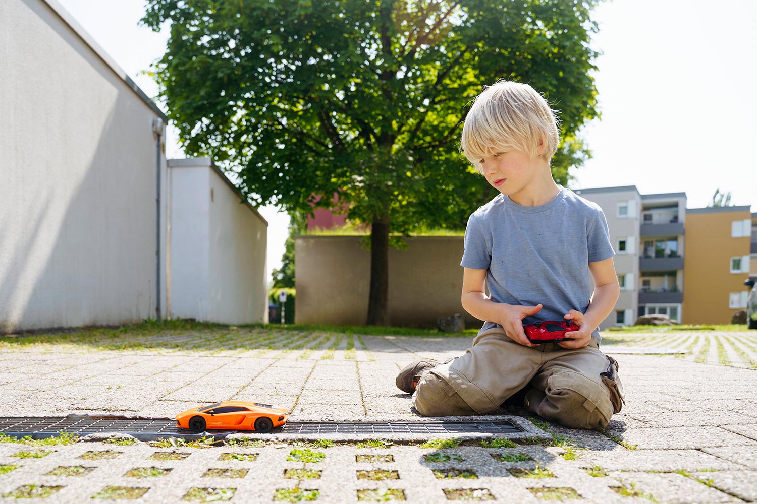 Kind spielt im Freien mit einem ferngesteuerten Spielzeugauto