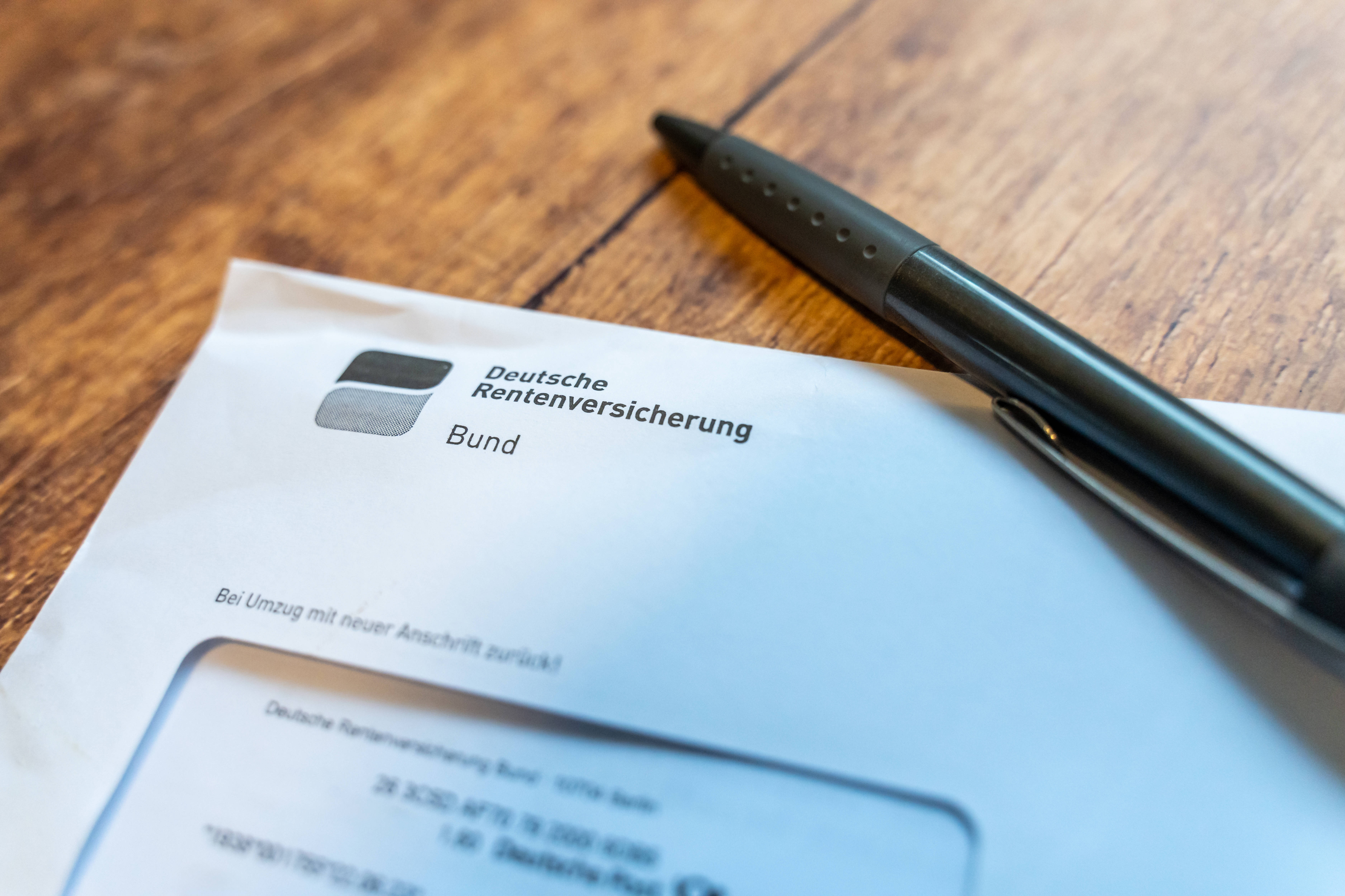 Info der Rentenversicherung Ein Brief mit Absender Deutsche Rentenversicherung liegt auf einem Tisch, darauf ein Kugelschreiber