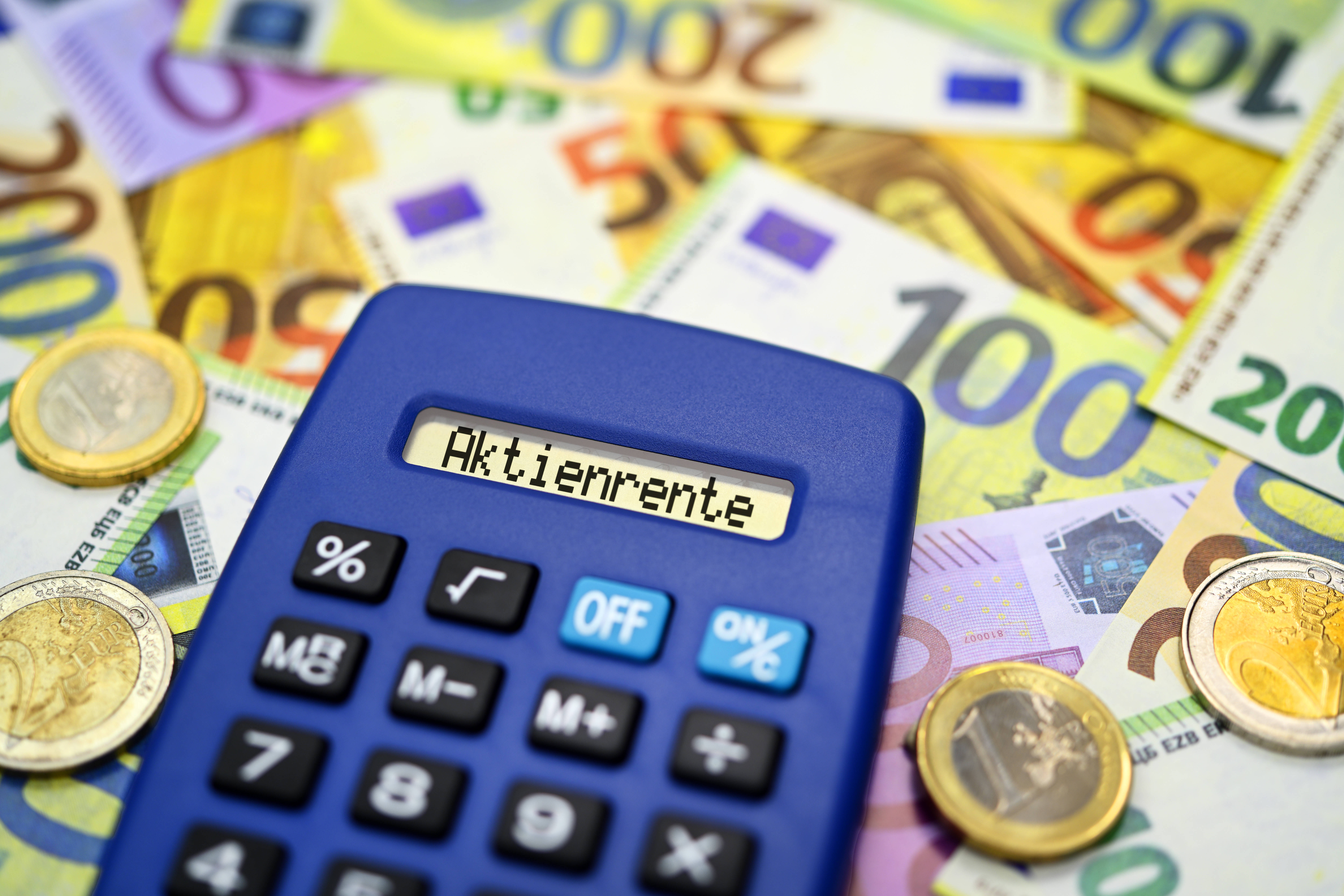 Aktienrente Die Bildmontage zeigt einen Taschenrechner mit Aufschrift Aktienrente im Display, er liegt auf vielen Euro-Geldscheinen