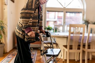 Seniorin mit Rollator in ihrer Wohnung