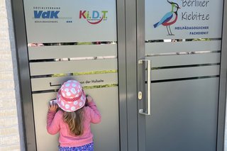 Auf dem Bild ist ein kleines Mädchen vor dem neuen Standort Berliner Kiebitze zu sehen. 