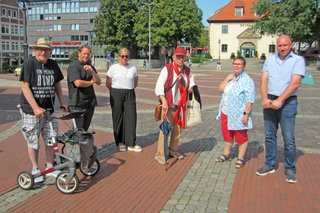 Die VdKler mit den Vertretern der Stadtverwaltung auf rotem Kopfsteinpflaster