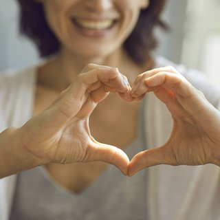 Eine Frau formt mit den Händen ein Herz