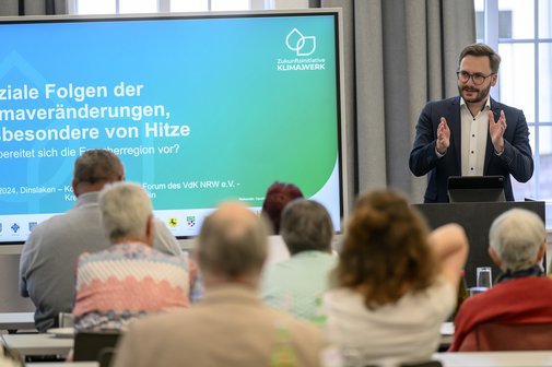 Ein Referent hält vor vielen Menschen einen Vortrag.