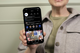 Eine Frau hält ein Smartphone in die Kamera. Auf dem Smartphone ist die Instagram-Seite vom VdK Rheinland-Pfalz zu sehen