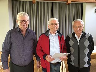Gruppenbild mit drei Männern einer mit einer Urkunde