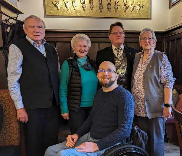 Gruppenfoto: Hinten 4 ältere Personen, vone ein junger Mann im Rollstuhl.