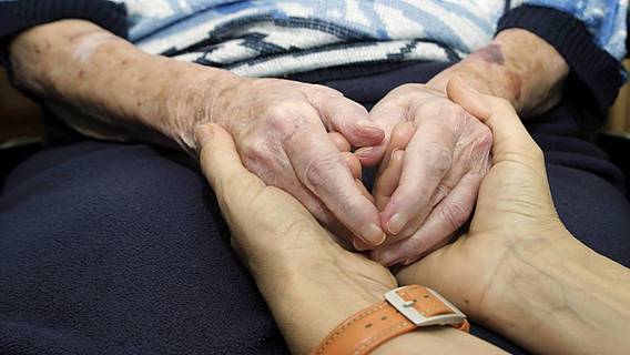 Symbolfoto: Junge Hände halten die Hände eines alten Menschen
