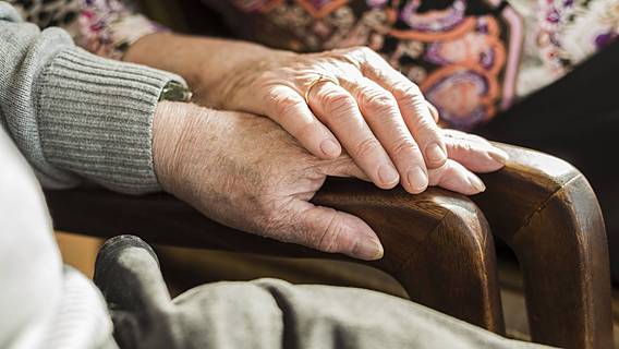 Symbolfoto: Älteres Paar hat die Hände aufeinander gelegt.