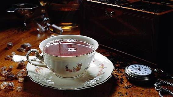 Symbolfoto: Eine Porzellantasse mit Tee steht auf einem Tisch.