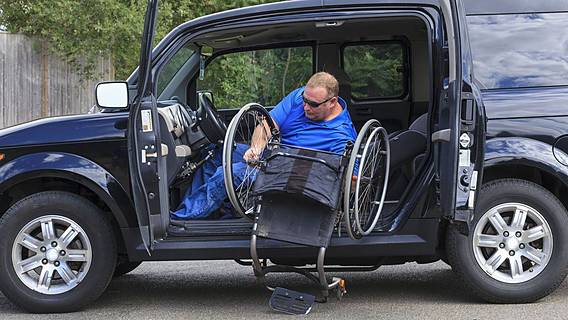 Symbolfoto: Ein Rollstuhlfahrer lädt seinen Rollstuhl aus einem behindertengerecht umgebauten Auto aus.